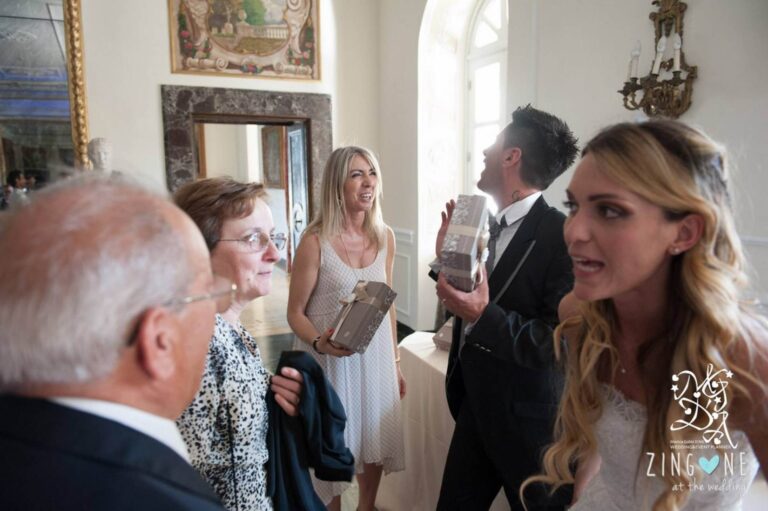 Monica greets a bride, groom and their families inside a frescoed palazzo entrance hall, MGDA Events