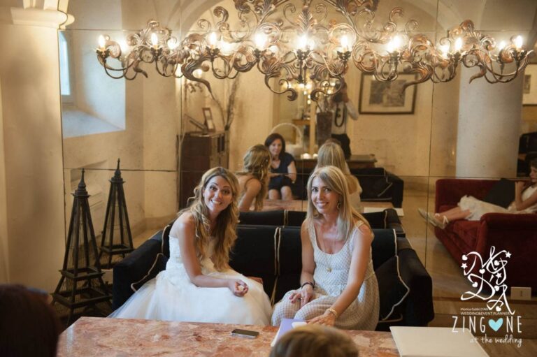 Monica and a groom share a laugh over a glass of prosecco in a frescoed hotel bar, MGDA Events