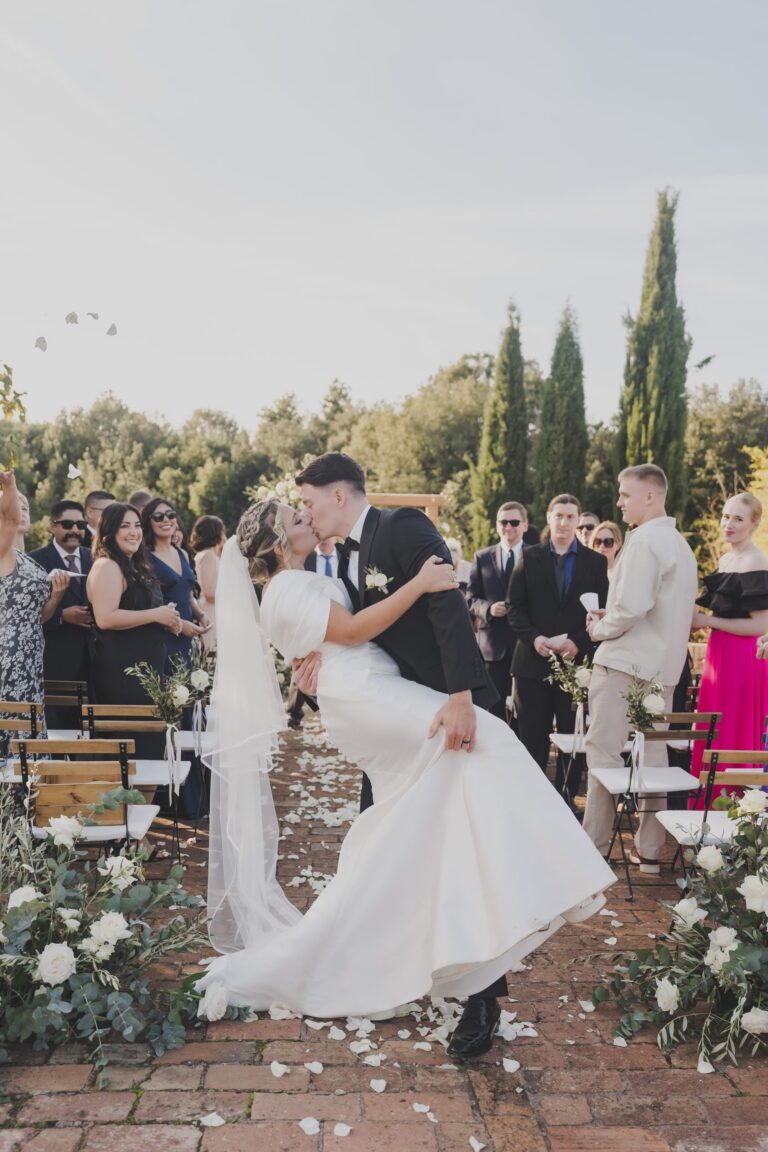The groom dips the bride for a kiss as they walk back down the aisle at Borgo Gallinaio, Michele Monasta Photography