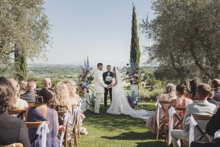 A spring ceremony in the olive grove at Borgo Argiano, the valley open behind the couple, Michele Monasta Photography