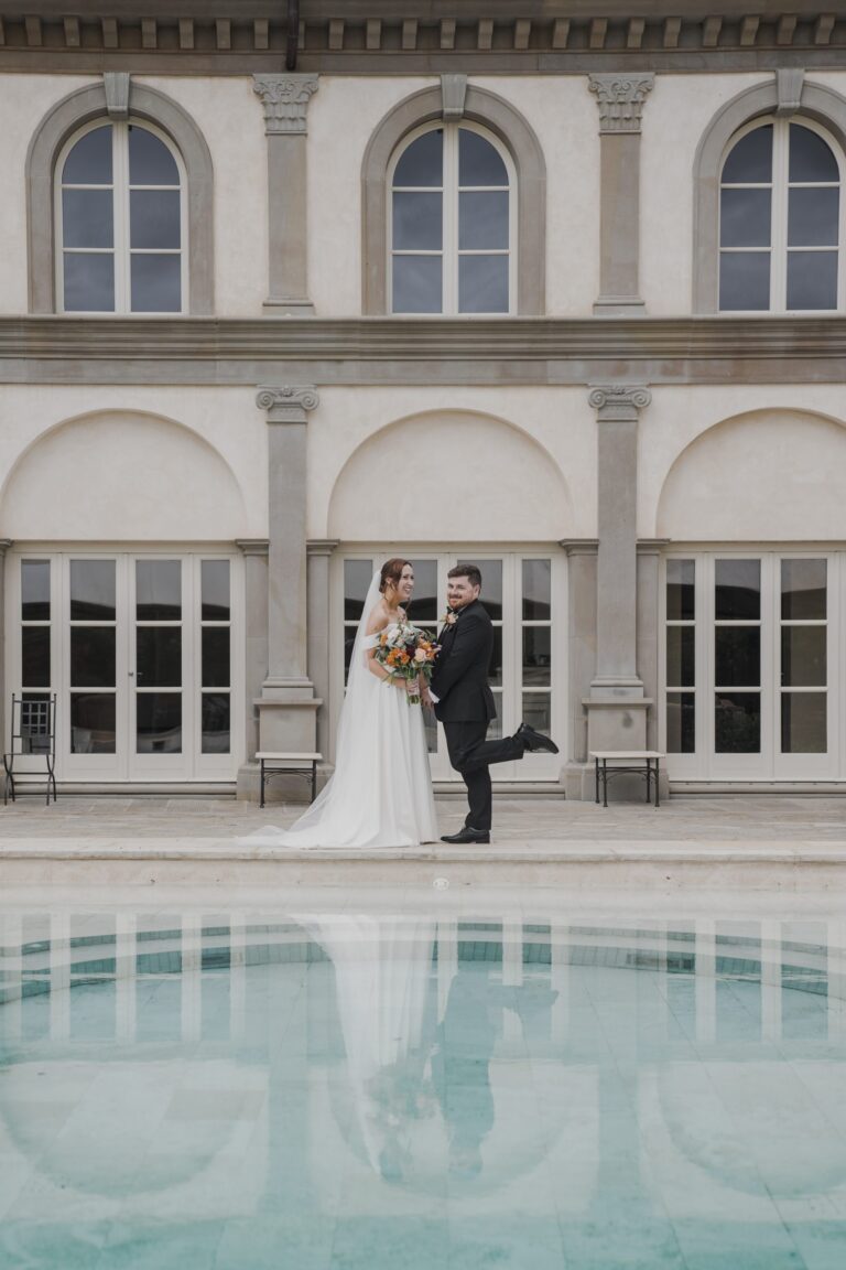 The couple reflected in the pool in front of La Corte dei Papi on the hills of Cortona, on an autumn elopement, Michele Monasta Photography