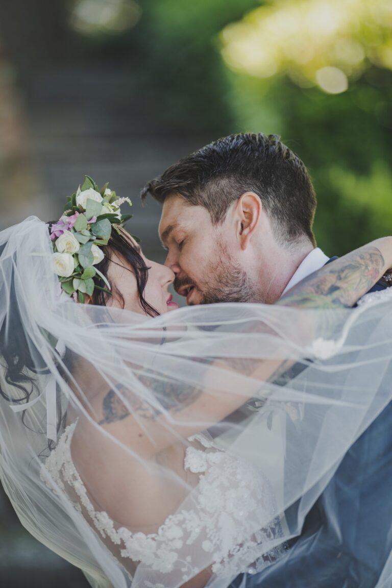 A kiss wrapped in the bride's veil at Castello di Bibbione, Michele Monasta Photography