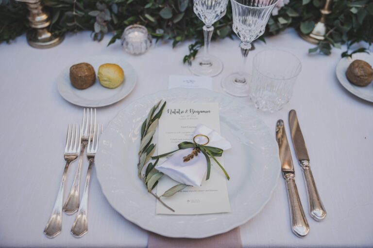 A place setting with an olive sprig and printed menu at Castello di Bibbione, Michele Monasta Photography