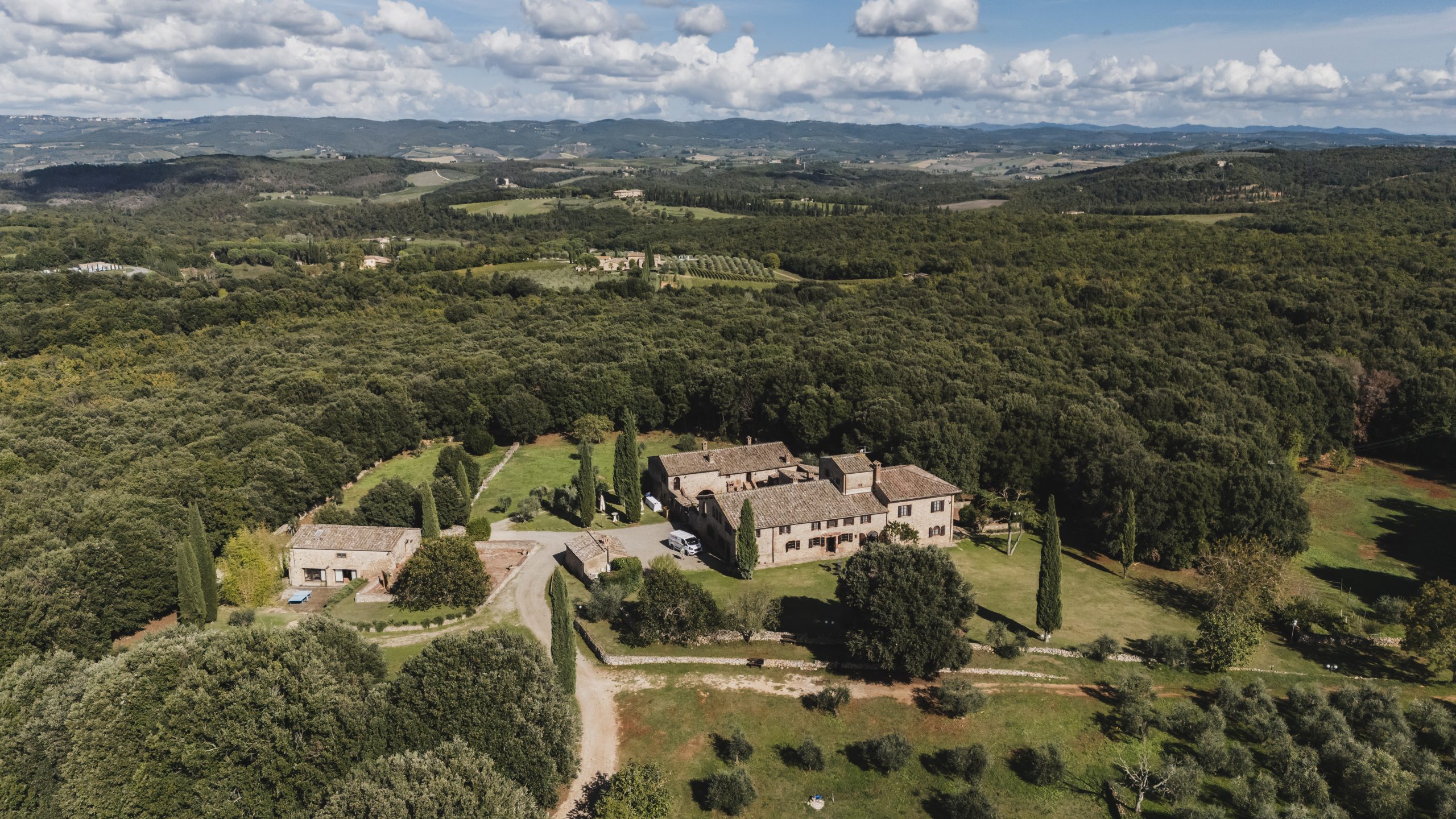 Borgo Gallinaio from the air, set among woods and cypresses in the hills near Siena, Michele Monasta Photography