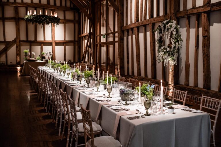 The Great Barn interior, long tables with green glassware and candles, Micklefield Hall