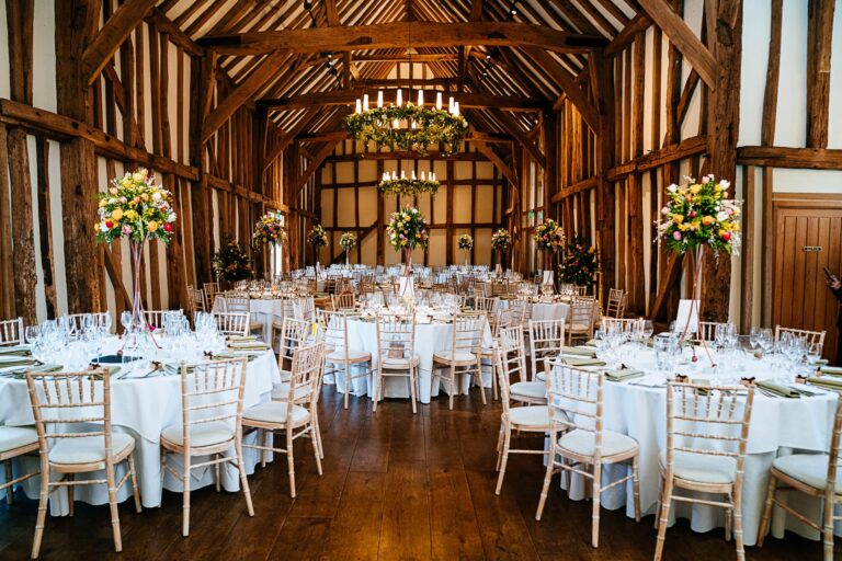 The Great Barn interior, round tables and white linen in daylight, Micklefield Hall