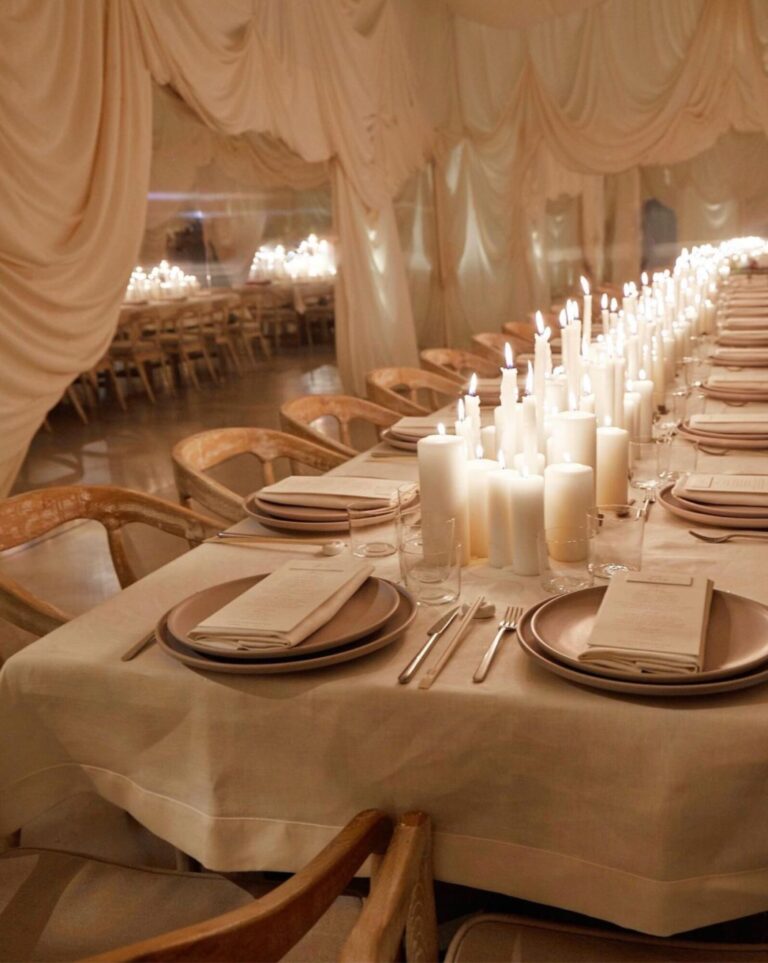 A long table of pillar candles beneath softly draped fabric, Mindy Weiss Party Consultants