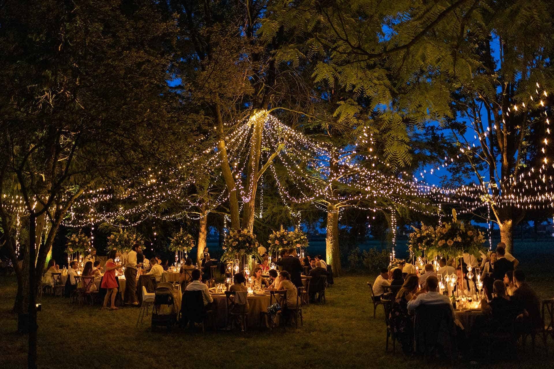 Fairy lights strung between the trees over the dinner at dusk, Mirko Zago, Sparkling Weddings and Events