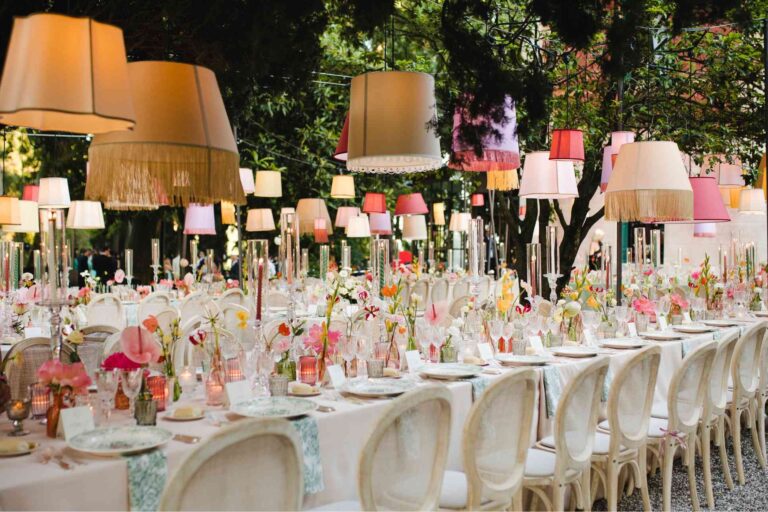 A long table under a canopy of lampshades, bright flowers the length of it, Mirko Zago, Sparkling Weddings and Events