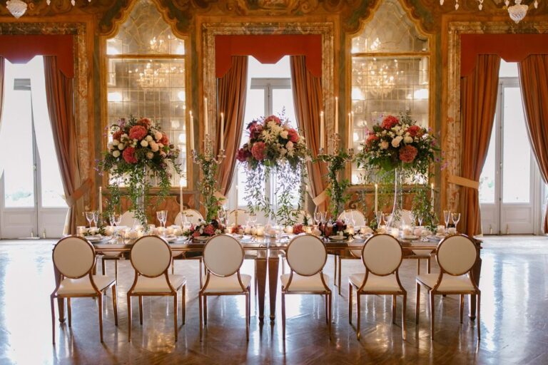Reception table laid beneath chandeliers in a frescoed room at Villa Erba, Lake Como, Mitheo Events