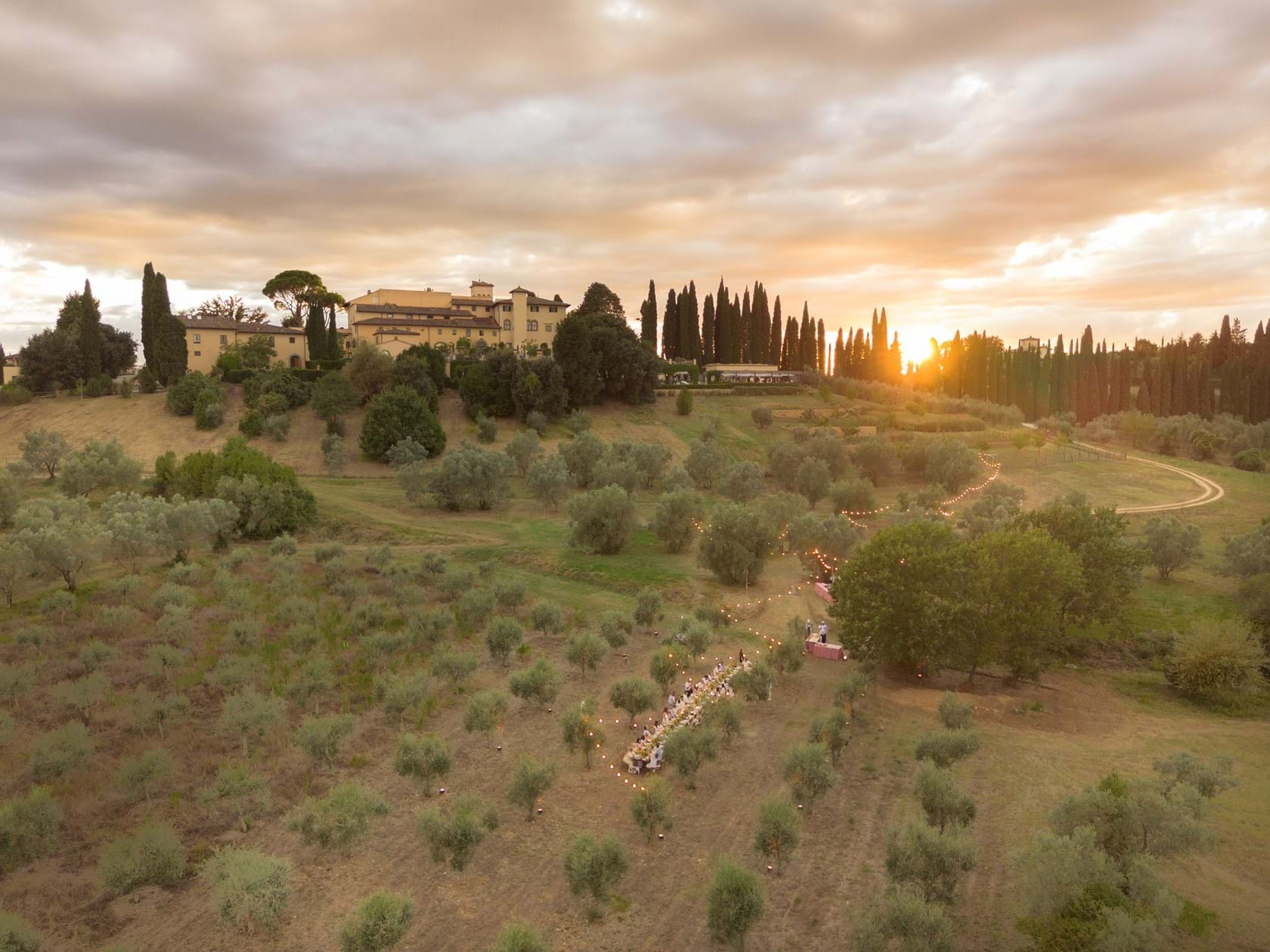 Aerial view of Como Castello del Nero among Tuscan olive groves at sunset, Mitheo Events
