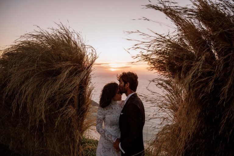 A couple kiss at sunset among pampas grass at Santa Thekla, Kefalonia, Mitheo Events