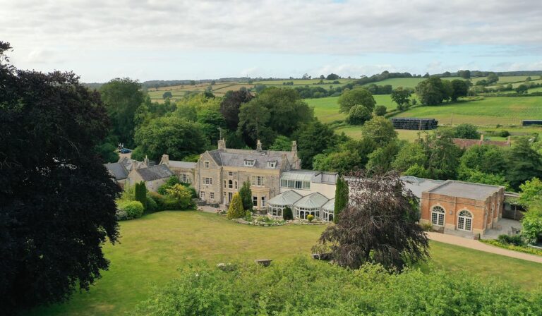 The house and its gardens seen from above, with the Somerset hills behind, Montigo Resorts Somerset at Charlton House