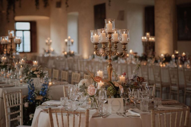 Candlelit reception room with gold candelabra and mixed florals on round tables, More Than Weddings