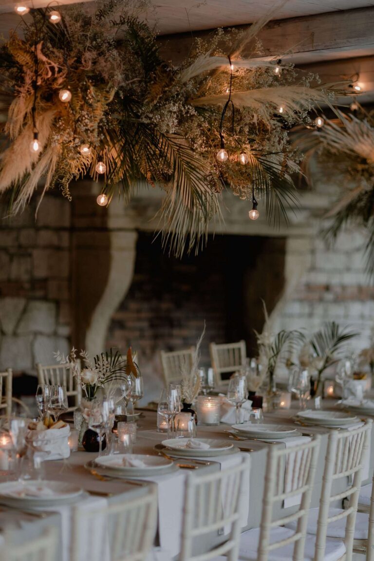 Reception tables beside a stone fireplace under dried-flower canopies, Verona, More Than Weddings