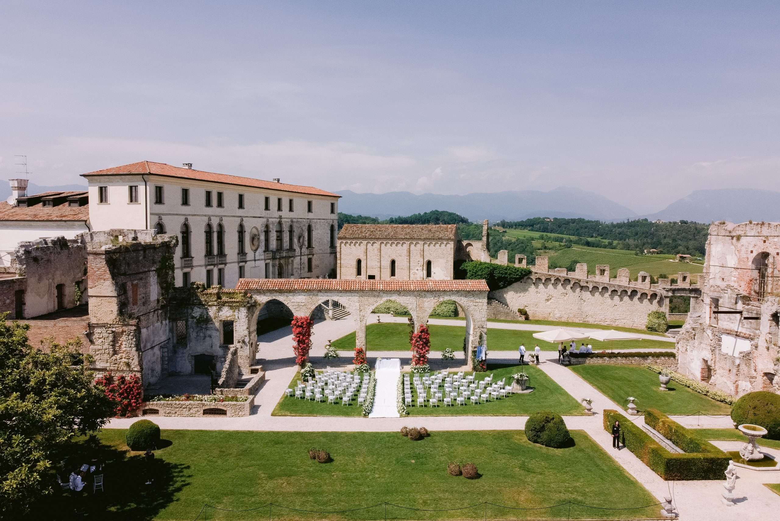 Aerial view of Castello di San Salvatore with the ceremony seating laid out on the lawn, More Than Weddings