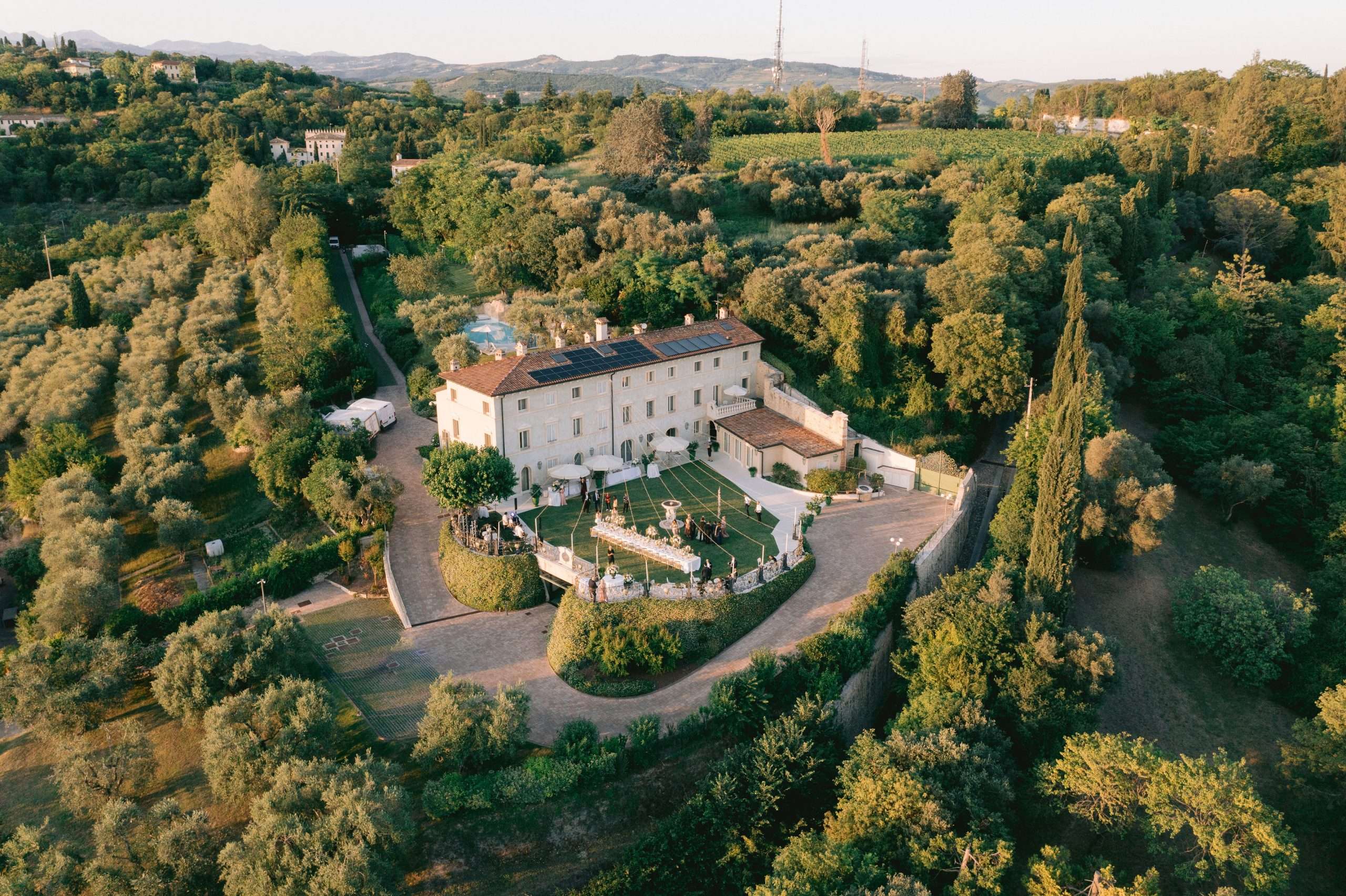 Drone view of a hilltop villa wedding near Verona, surrounded by olive groves and cypresses, More Than Weddings
