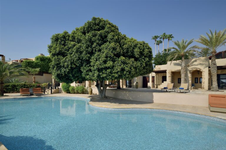 Garden pool with villa buildings in the background, Mövenpick Resort & Spa Dead Sea