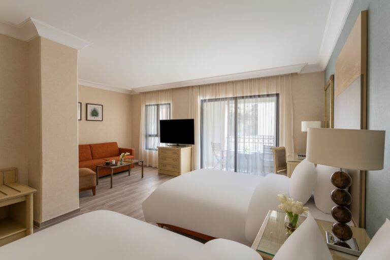Twin beds with sitting area and balcony doors beyond, Mövenpick Resort Petra