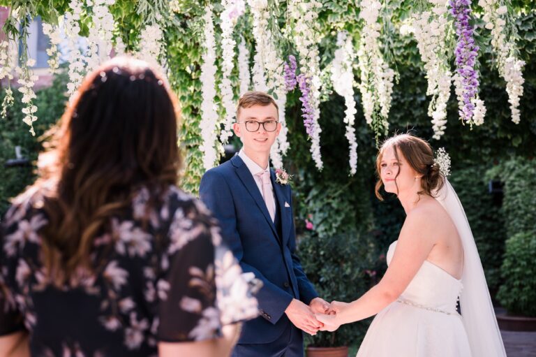 The ceremony under the hanging wisteria, the celebrant facing the couple, Mr and Mrs Wedding In Italy