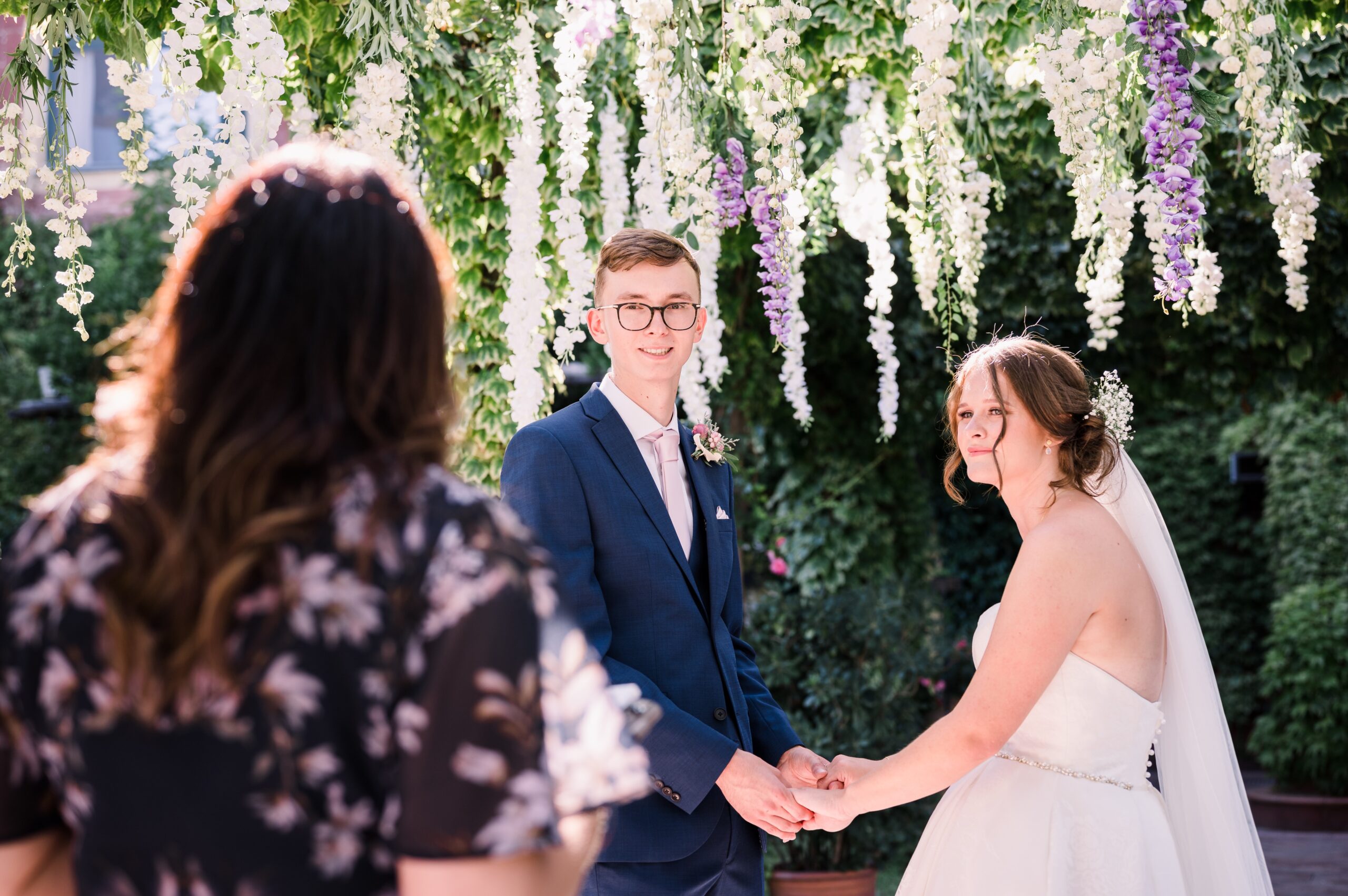 The ceremony under the hanging wisteria, the celebrant facing the couple, Mr and Mrs Wedding In Italy