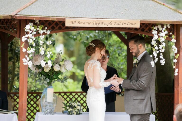 A ceremony in a wooden gazebo hung with white flowers, Mr and Mrs Wedding In Italy