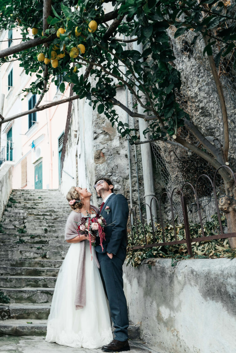 The couple on stone steps beneath a pergola of lemons, Mr and Mrs Wedding In Italy