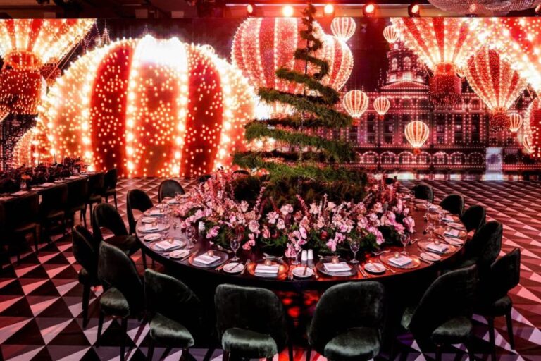 Round table with a floral and topiary centrepiece beneath glowing lanterns and balloon-shaped lights, MY Event Design