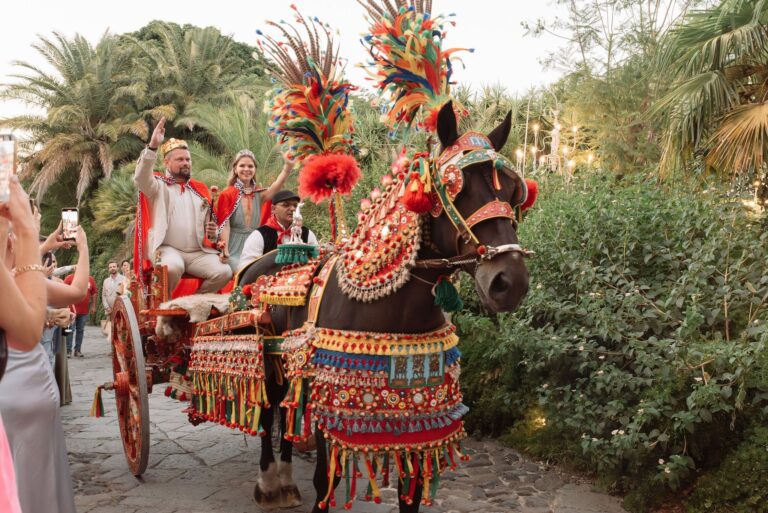 A painted Sicilian cart in full plumed harness, the couple riding in it, My Sicily Wedding