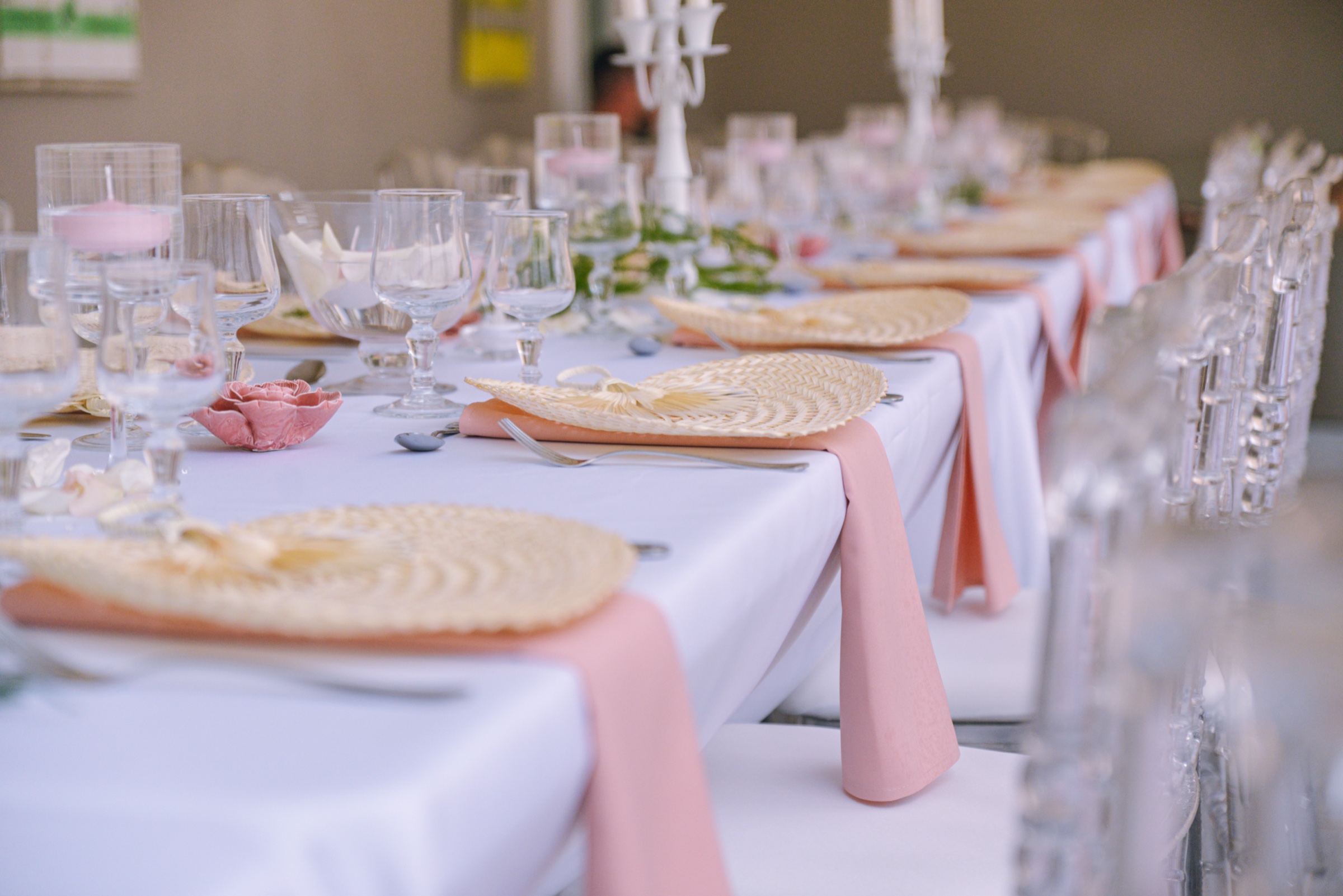 A long reception table with woven placemats, blush napkins and glassware, Myl'Evasions