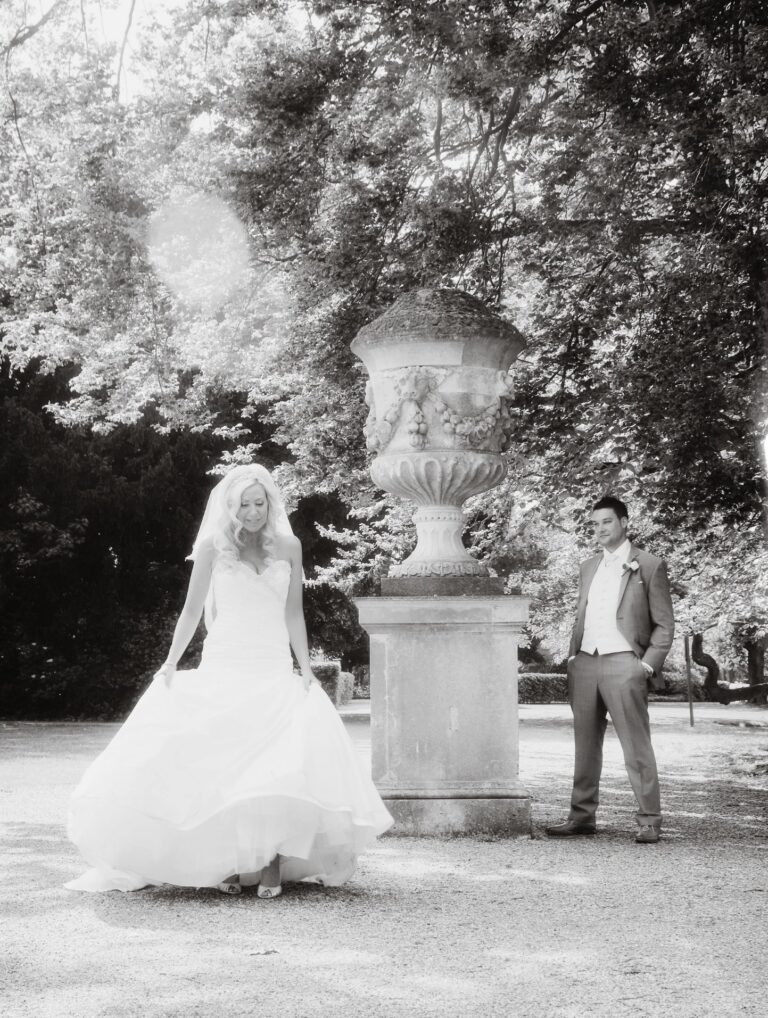 A bride and groom in the gardens at Oatlands Park Hotel, Surrey, Nadine Pyke Make Up Artist