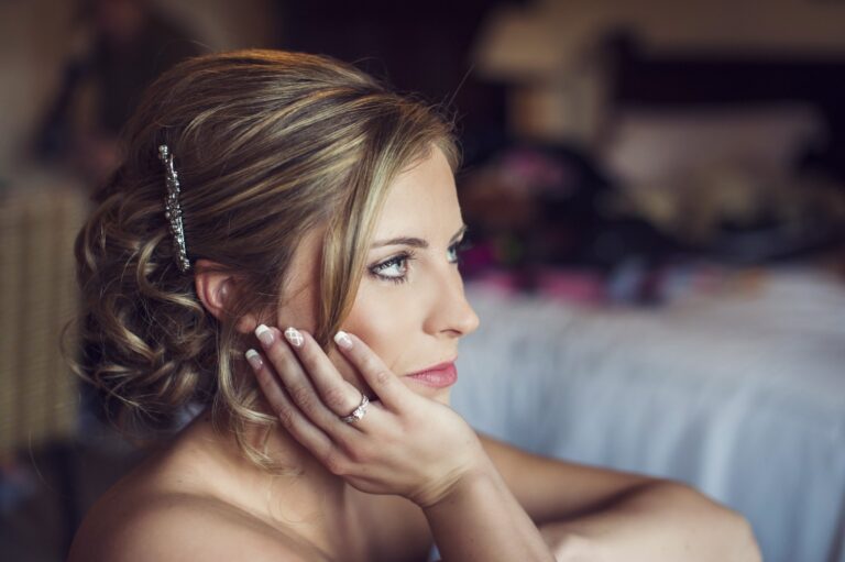 A bride resting her chin on her hand, soft upswept hair, Nadine Pyke Make Up Artist