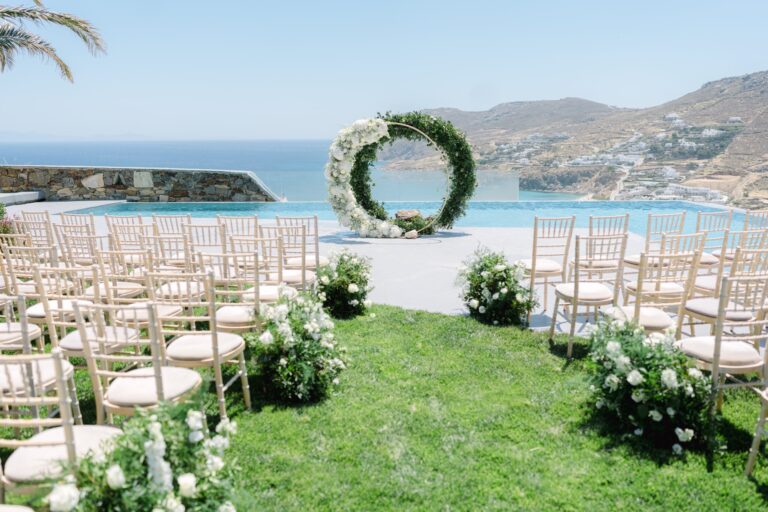 Ceremony chairs on the lawn facing a floral hoop and a pool, Naido Wedding