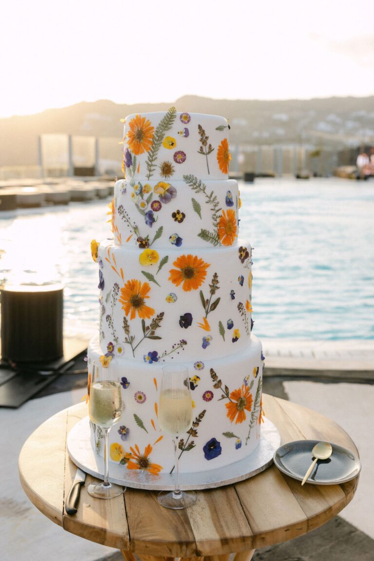 Wedding cake decorated with pressed flowers beside the water, Naido Wedding