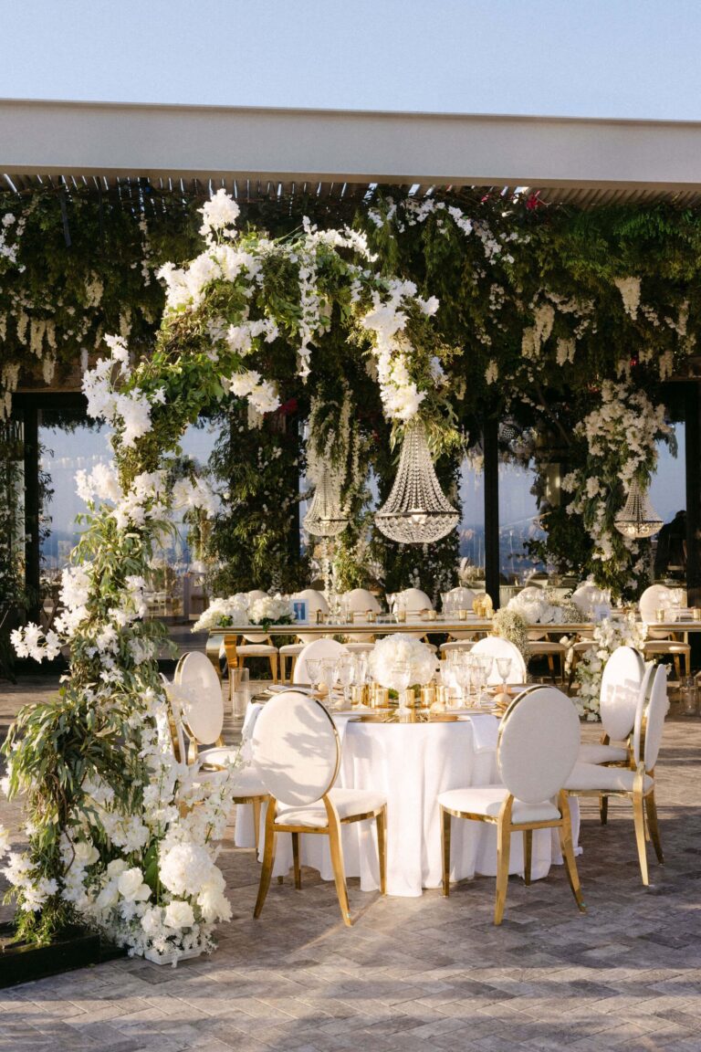 Reception tables beneath a floral and crystal arch, Naido Wedding