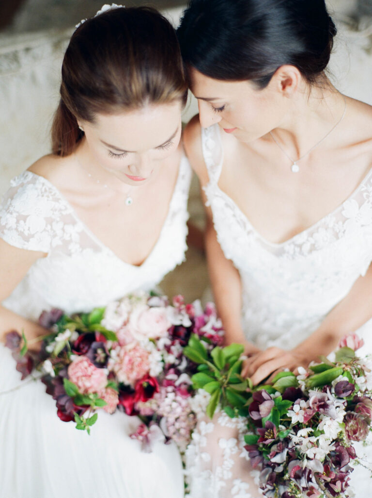 Two brides in Naomi Neoh gowns holding bouquets, Delicately Decadent styled shoot