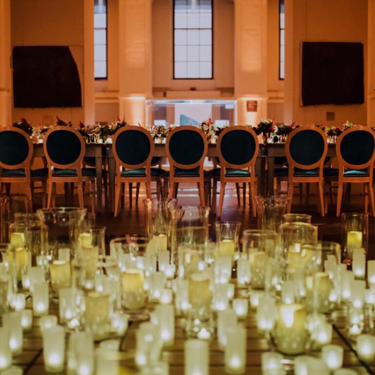 A dinner table lit with candles at a Niemierko wedding at the British Museum