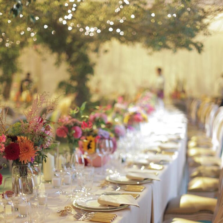 A long dinner table under a floral canopy at a Niemierko wedding