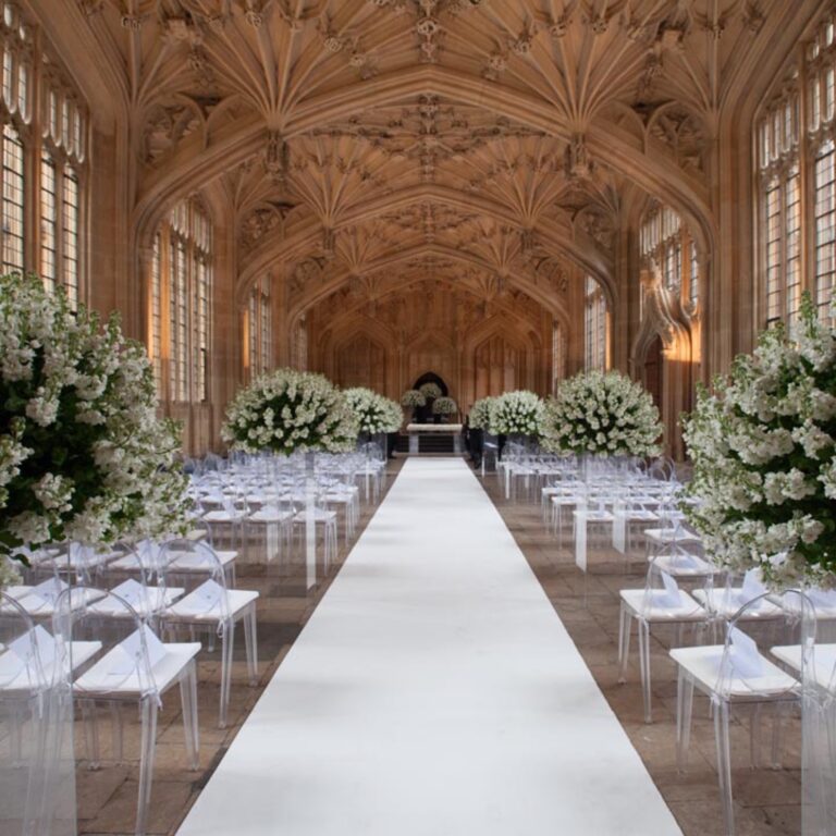 A white aisle through a vaulted hall at a Niemierko wedding at Oxford University