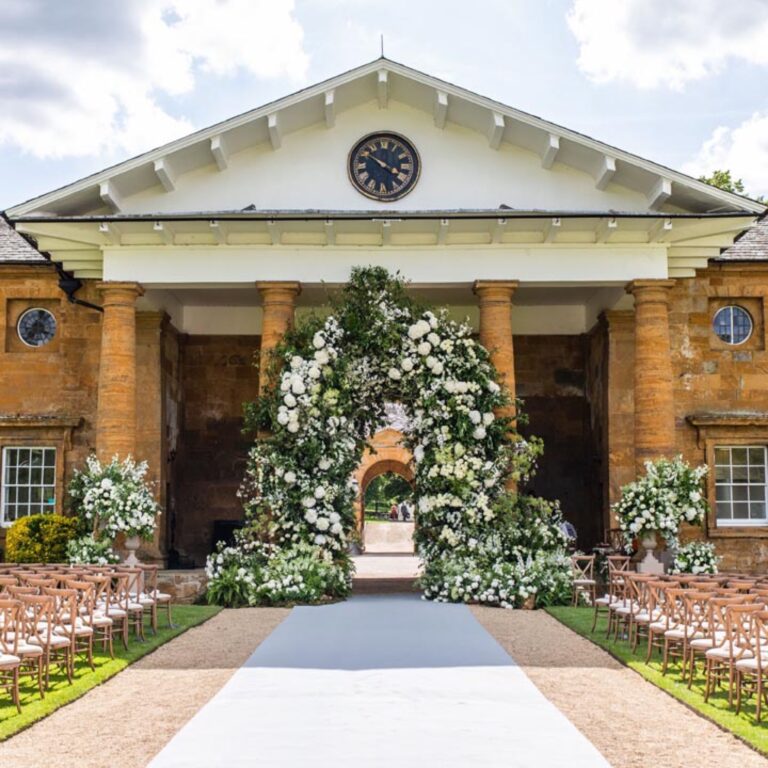 A floral arch in front of the house at a Niemierko wedding at Althorp House