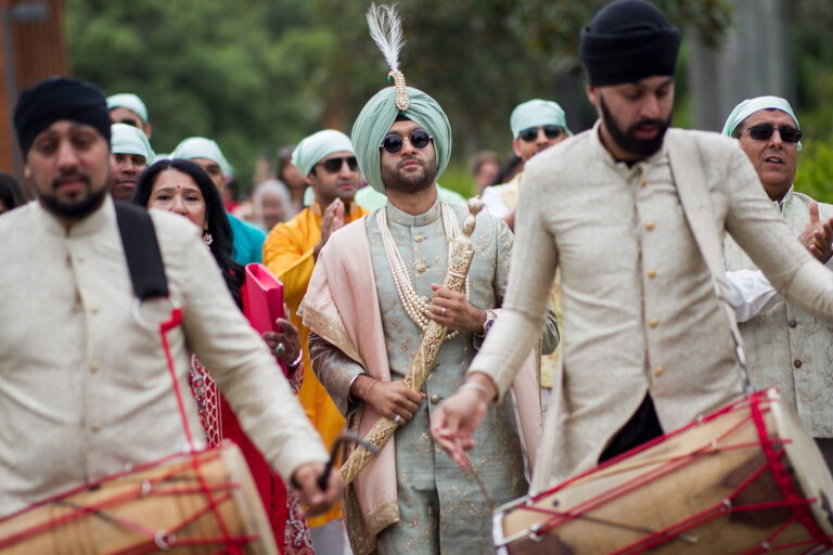 Groom and family celebrating with dhol players during the baraat, Nilyum Wedding and Event Design