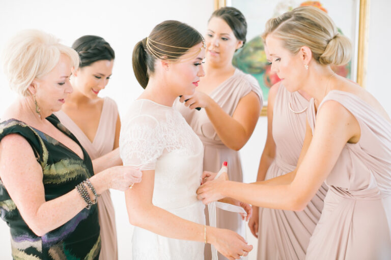 Bridesmaids helping the bride into her dress, Nilyum Wedding and Event Design
