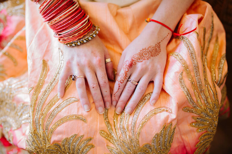 Henna on the bride's hands against an embroidered outfit, Nilyum Wedding and Event Design