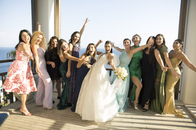 Bride and wedding guests laughing together on a sunlit terrace, Nilyum Wedding and Event Design