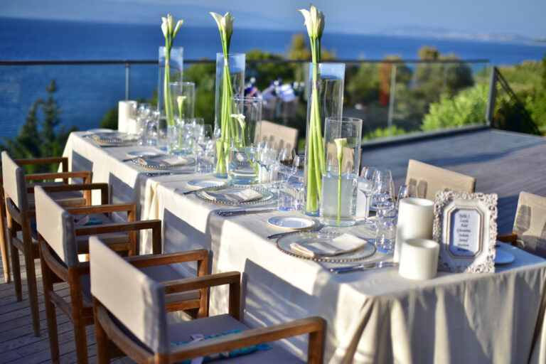 Terrace table dressed with calla lilies in glass vases above the sea, Nilyum Wedding and Event Design