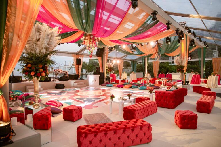 Marquee with coloured drapes, red tufted seating and a patterned dance floor, Nilyum Wedding and Event Design