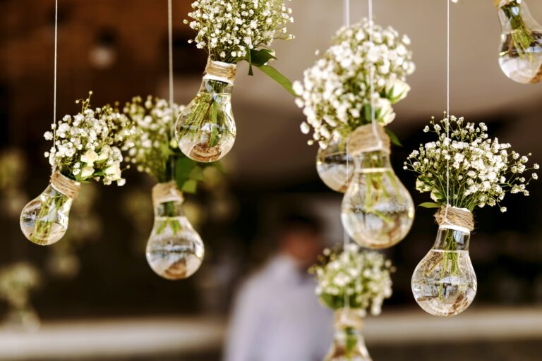 Glass bulbs holding gypsophila hanging above a reception, Nordic Adventure Weddings