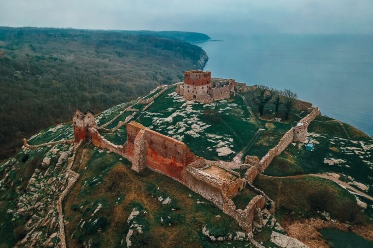 Aerial view of a ruined hilltop fortress above the sea, Nordic Adventure Weddings