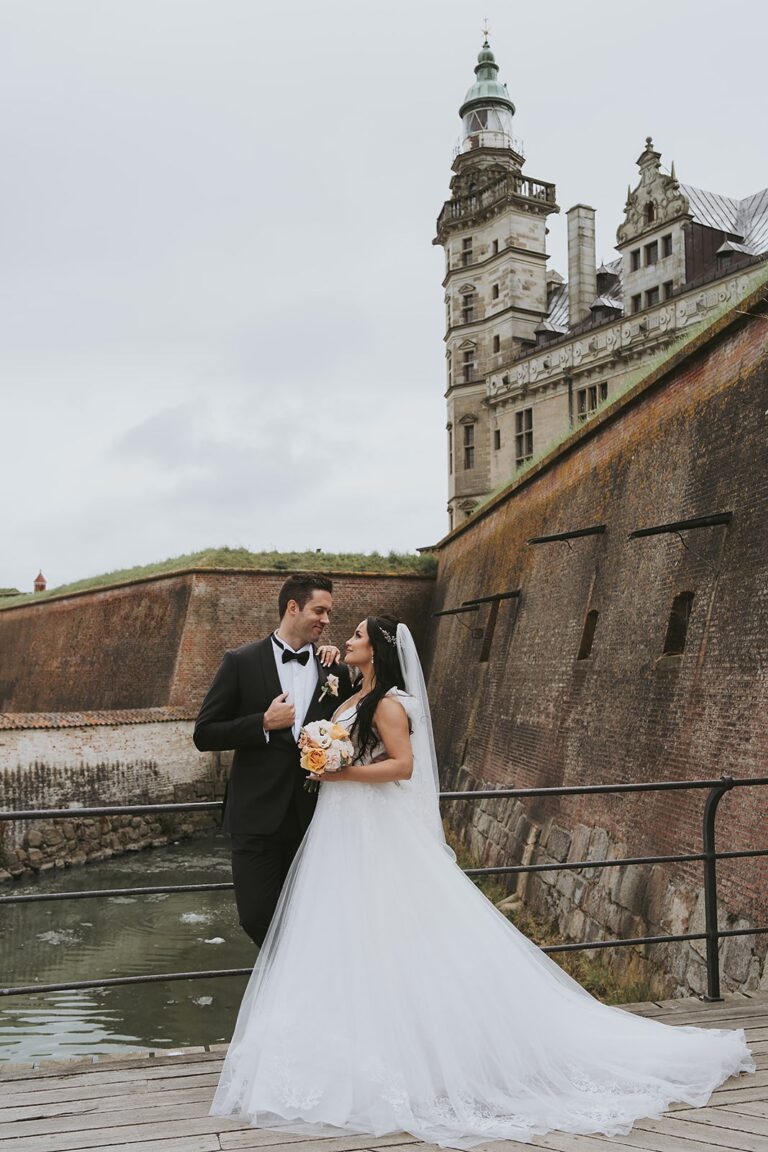 Couple beside a fortress wall with a castle tower behind, Nordic Adventure Weddings