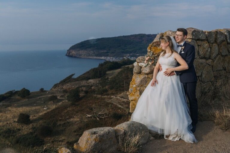 Couple on a coastal headland, the bride in a tulle gown, Nordic Adventure Weddings